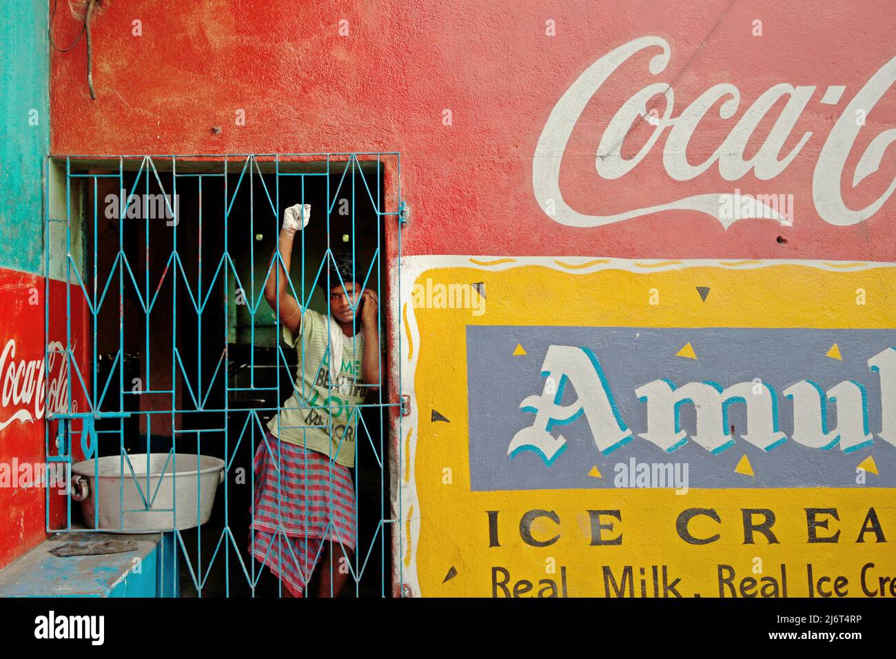 Porträt eines Arbeiters, der an der Hintertür eines Cafés mit Chai und alkoholfreien Getränken in Westbengalen, Indien, telefoniert. © Reynold Sumayku Stockfoto