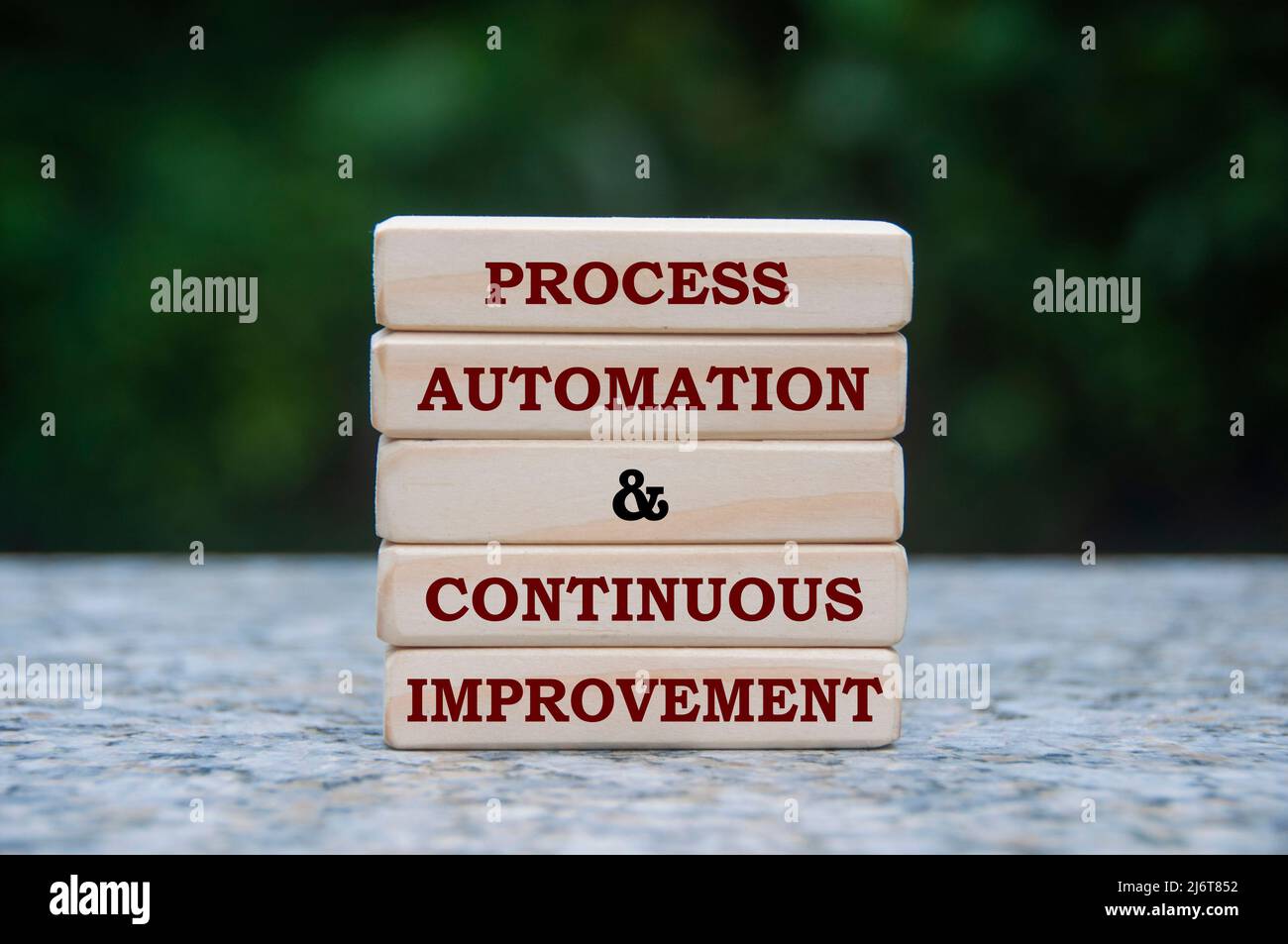 Text zur Prozessautomatisierung und kontinuierlichen Verbesserung auf Holzblöcken mit unscharfem Naturhintergrund. Prozessverbesserung und Geschäftskonzept Stockfoto