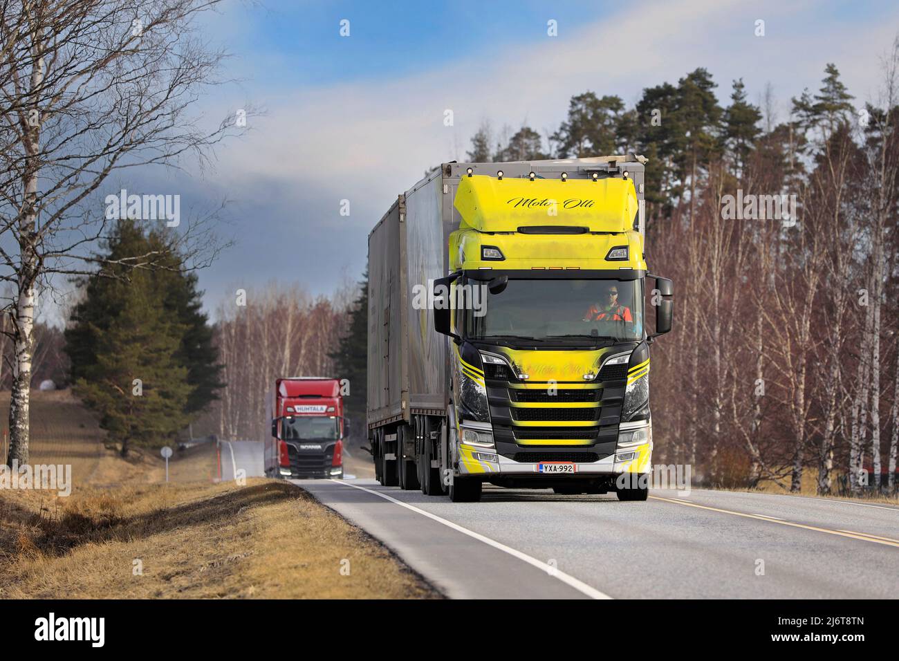 Scania LKW und Holzschnitzeltransporter von Moto-Olli Oy und rot Scania Huhtala auf dem Highway 52 an einem Frühlingsmorgen. Salo, Finnland. 18. April 2022. Stockfoto