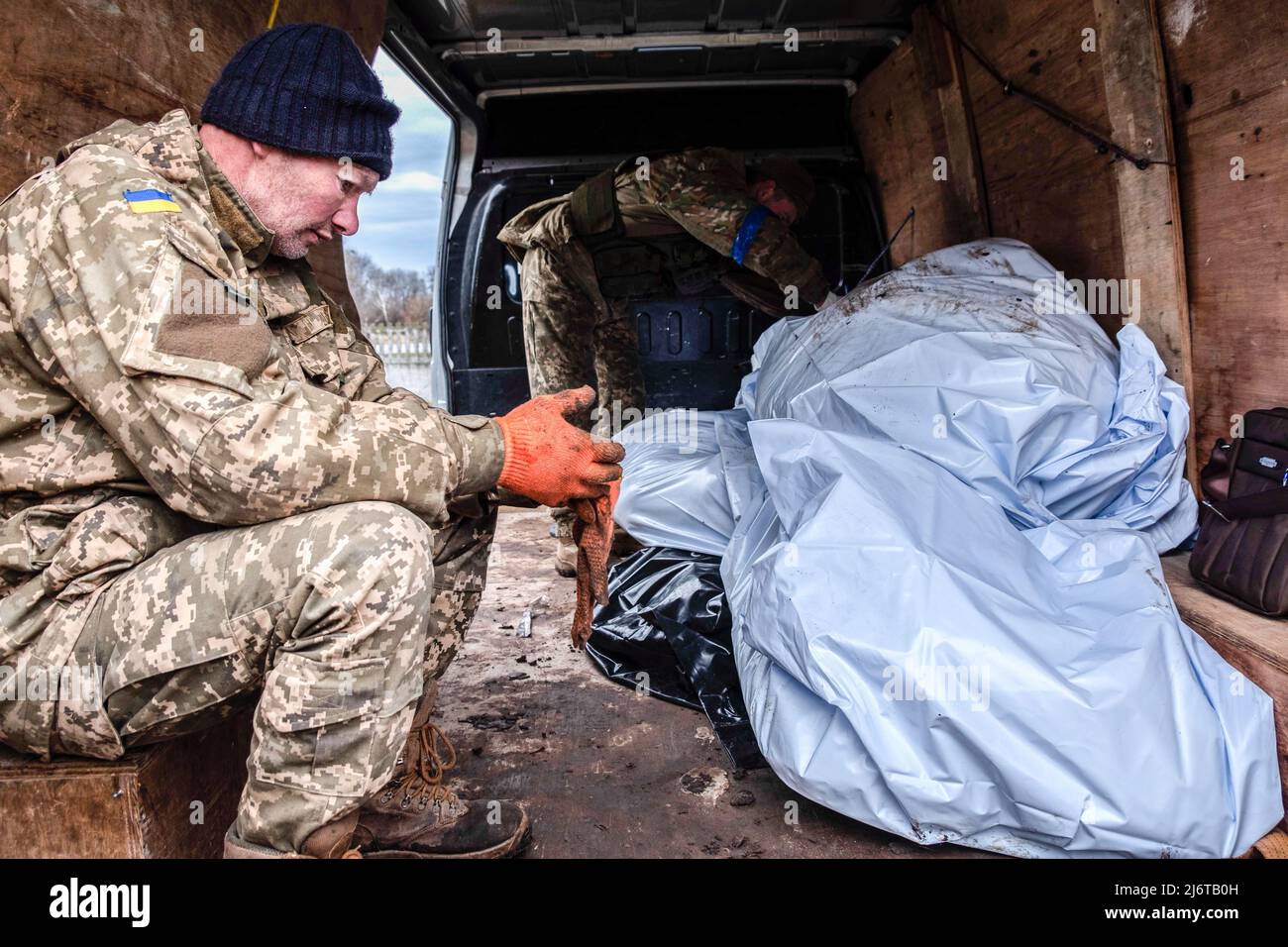 Die Mitglieder des Polizei-Such- und Bergeteams sind in einem Lastwagen mit Leichensäcken zu sehen. Makariv ist eine Stadt im Rajon Bucha, Kiew, 60 Kilometer westlich der Hauptstadt der Ukraine. Seit mehr als einem Monat unter russischer Besatzung hat Makariv keine Strom-, Wasser-, Gas- oder Telekommunikationsleitung. Die russischen Angriffe zerstörten vierzig Prozent des Gebiets, und es wurden viele Massenmorde verzeichnet. Darüber hinaus zerstörten russische Truppen Infrastrukturen und förderten einige Gebiete. (Foto von Rick Mave / SOPA Images/Sipa USA) Stockfoto