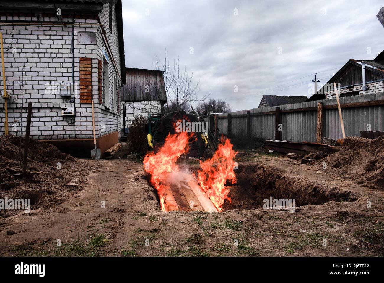 (ANMERKUNG DER REDAKTION: Bild zeigt den Tod)Ein Sarg mit einer Leiche im Inneren wird in einer Grube in Makariv verbrannt. Makariv ist eine Stadt im Rajon Bucha, Kiew, 60 Kilometer westlich der Hauptstadt der Ukraine. Seit mehr als einem Monat unter russischer Besatzung hat Makariv keine Strom-, Wasser-, Gas- oder Telekommunikationsleitung. Die russischen Angriffe zerstörten vierzig Prozent des Gebiets, und es wurden viele Massenmorde verzeichnet. Darüber hinaus zerstörten russische Truppen Infrastrukturen und förderten einige Gebiete. (Foto von Rick Mave / SOPA Images/Sipa USA) Stockfoto