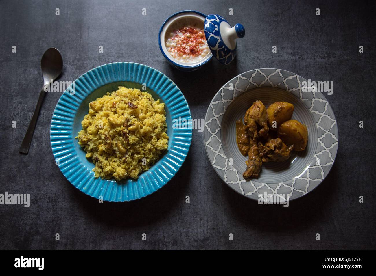 Indisches Gericht Pulao aus Basmati-Reis und Hühnerfleisch, serviert in einer Schüssel auf dunklem Hintergrund. Draufsicht, selektiver Fokus. Stockfoto