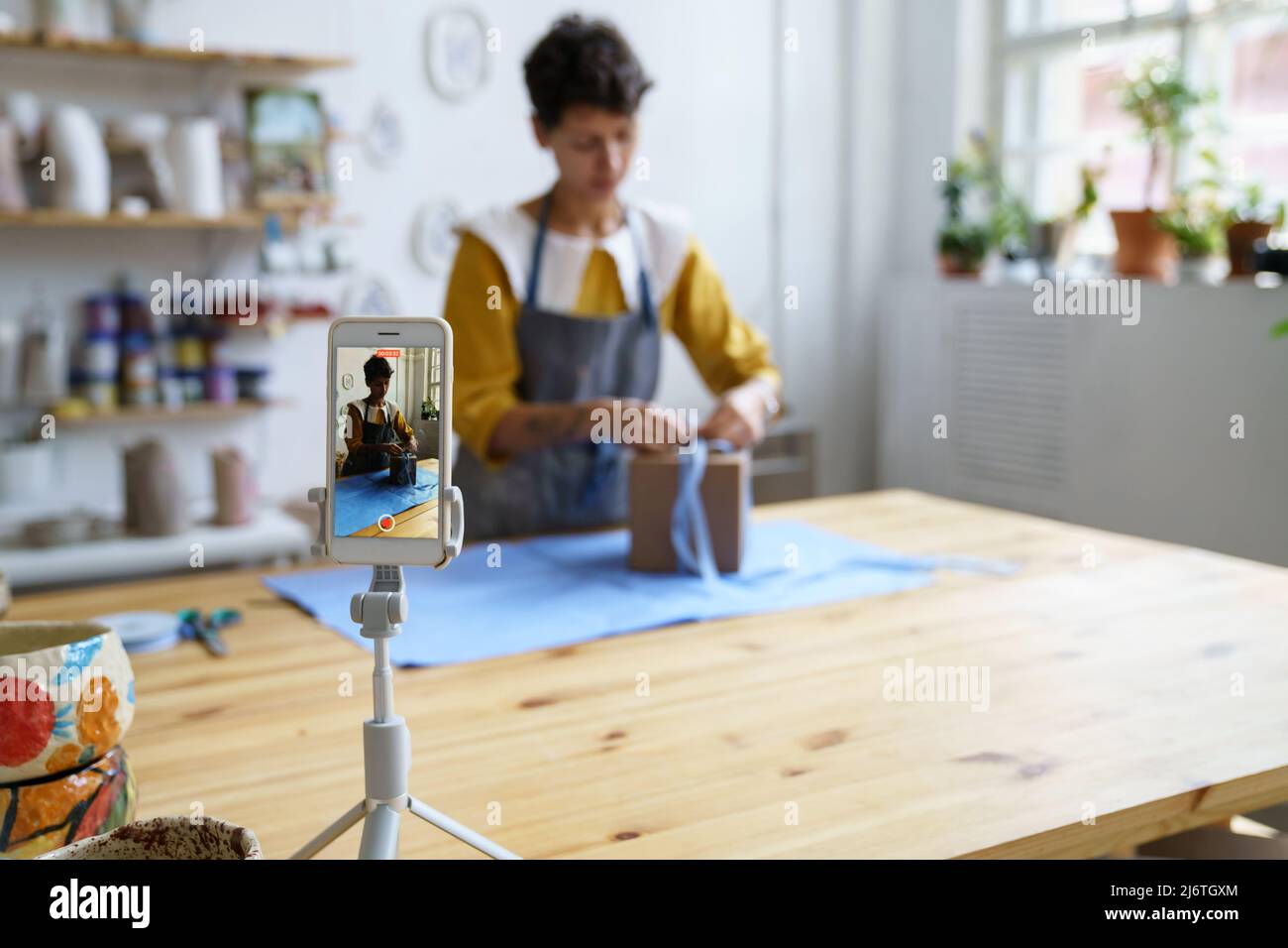 Junge Frau Töpferei Shop Besitzer Aufnahme kurze Tutorial, wie sicher packen Keramik für den Versand Stockfoto