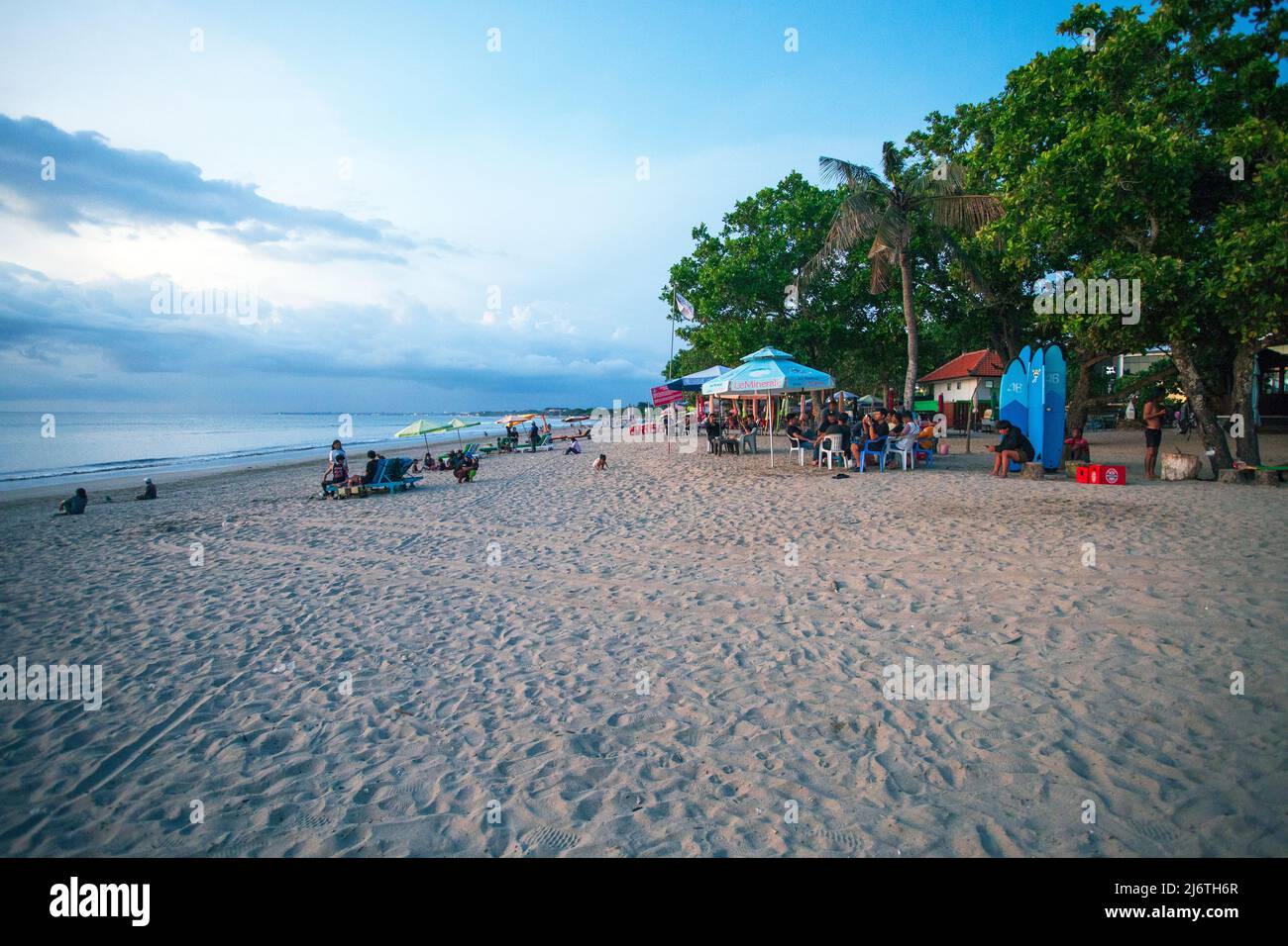 Abends am Kuta Beach in Bali mit Leuten, die auf Stühlen auf dem Sand sitzen. Stockfoto