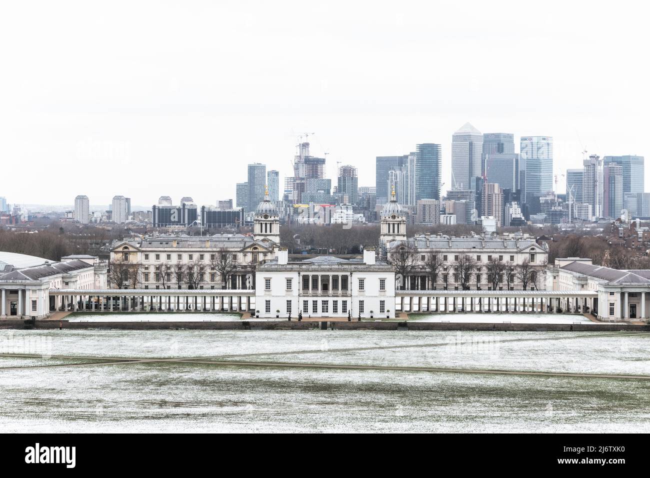 London, Großbritannien - 19. März 2022 - Blick auf das Queens House und Canary Wharf vom Greenwich Park im Winterschnee Stockfoto
