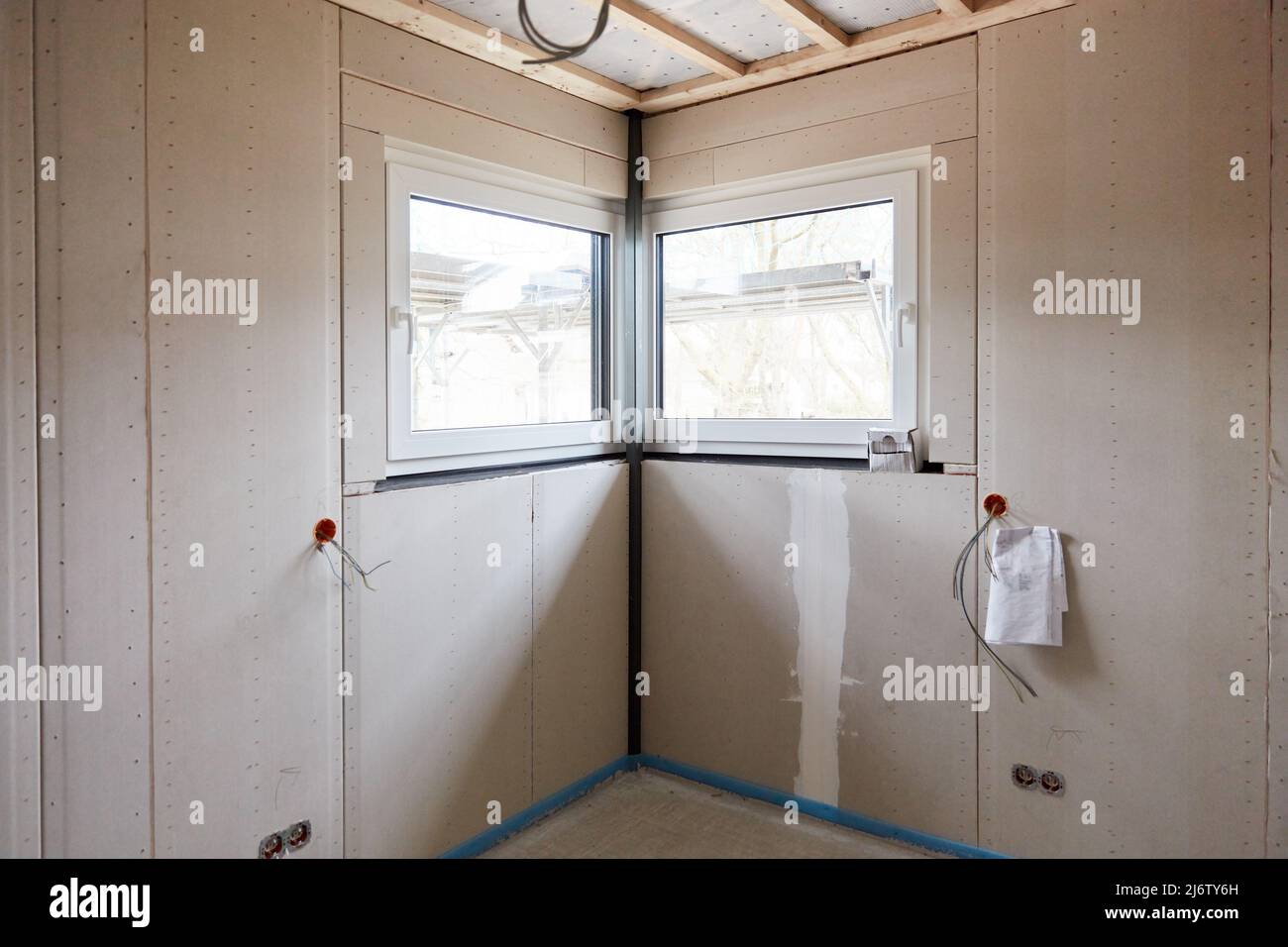 Kleines Eckfenster im Zimmer in der Innenarchitektur des Hauses als Neubau Stockfoto