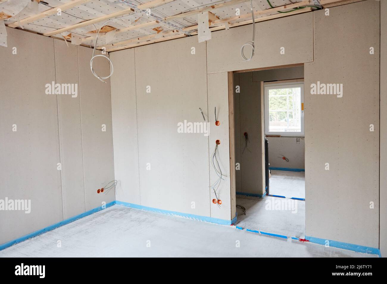 Ecke im Zimmer mit Türöffnung und frischem Estrich auf der Baustelle für den Hausbau Stockfoto