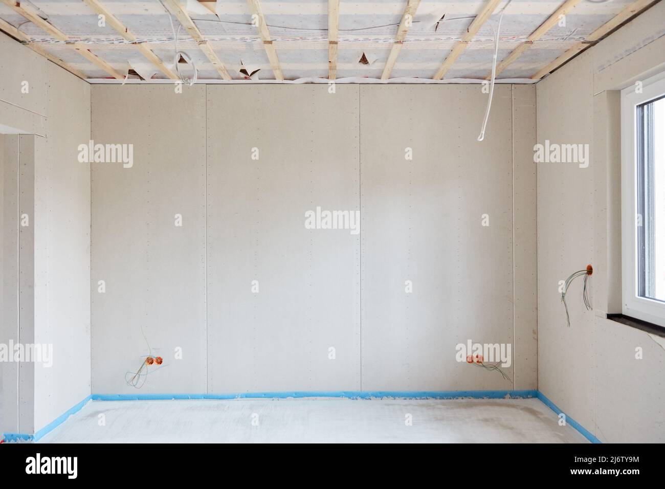 Gipskartonwand und Fenster in einem Neubau mit frischem Estrich auf dem Boden Stockfoto