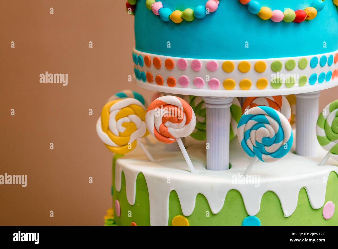 Schöner mehrfarbiger Kinderkuchen aus mehreren Schichten, verziert mit Süßigkeiten Stockfoto