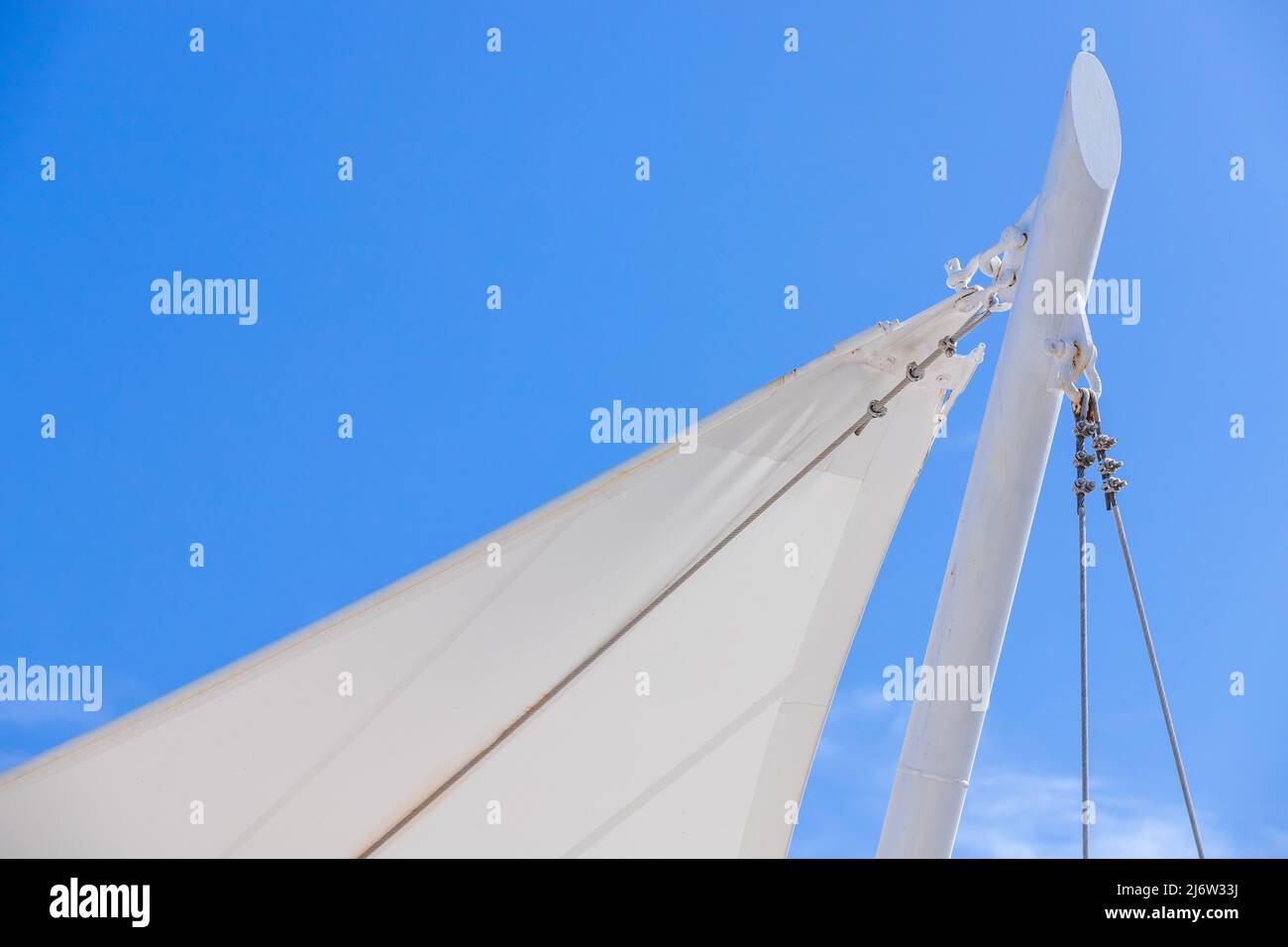 Weiße Markise in Form eines Segelschiffs steht unter blauem Himmel, Hintergrund des Strandresorts Stockfoto