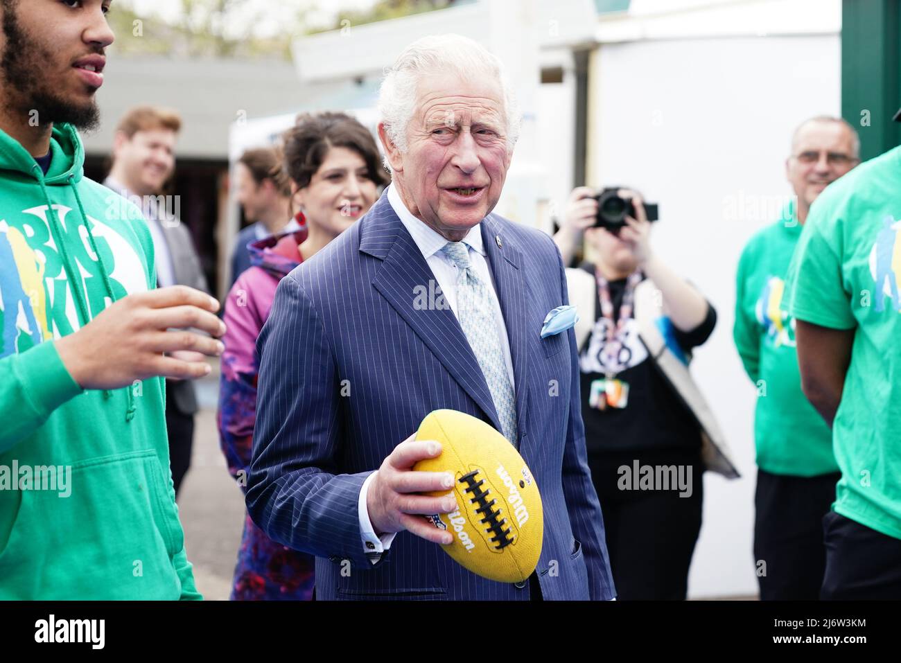 Der Prinz von Wales hält einen amerikanischen Fußball während eines Besuchs auf dem Dexters Adventure Playground in Brixton, Süd-London, wo er die jungen Menschen trifft, die von der BIGKID Stiftung unterstützt werden. Bilddatum: Mittwoch, 4. Mai 2022. Stockfoto