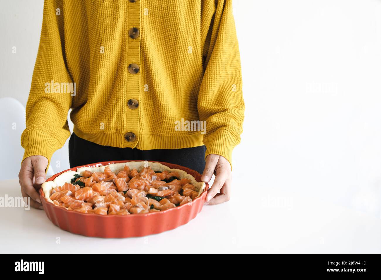 Frau kocht Quiche mit Lachs und Spinat. Kochen. Stockfoto