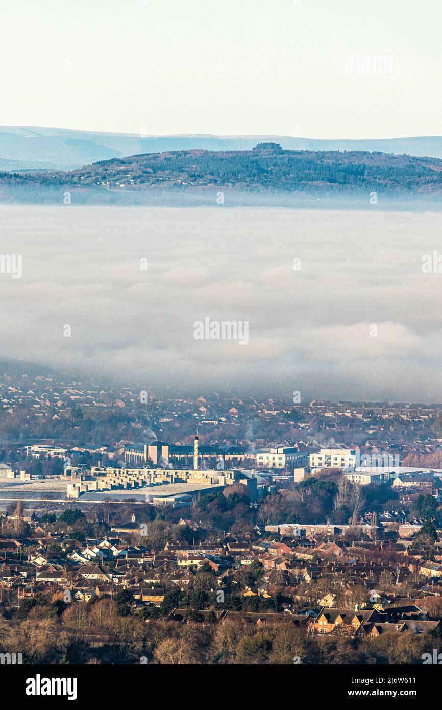 Eine Temperaturinversion, die Nebel verursacht, um die Stadt Gloucester, England, zu verdunkeln. Gloucester Business Park in Brockworth ist im Vordergrund und Mai Stockfoto