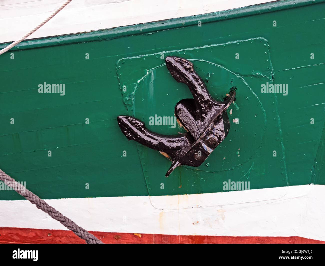 Nahaufnahme eines schwarzen Ankers auf dem farbenfrohen Schiffsrumpf Stockfoto