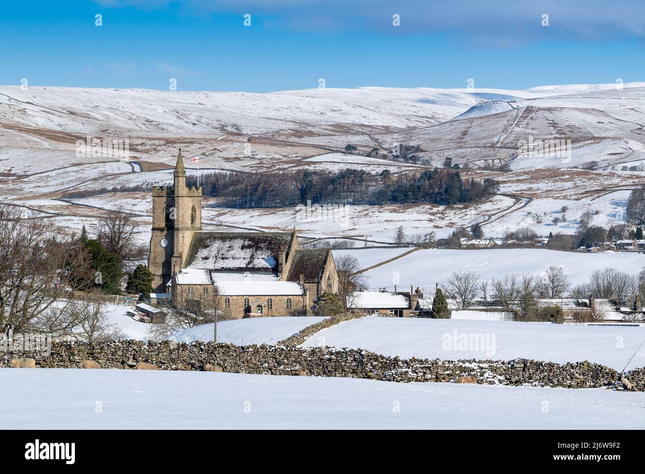 Die Kirche der Heiligen Margarete von Antiochia in Hawes hebt sich von der winterlichen Landschaft in Hawes, Wensleydale, North Yorkshire, Großbritannien, ab. Stockfoto