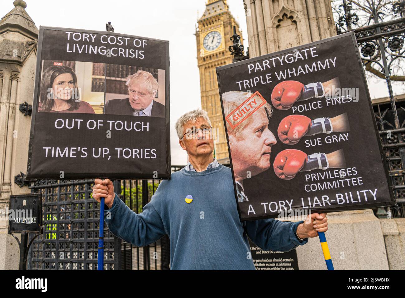 London, 4. Mai 2022. Ein Protestler hält Plakate vor dem Parlament gegen die Lebenshaltungskrise und die Party am Vorabend der Kommunalwahlen am 5. Mai, wenn die Wähler zur Wahl gehen, um lokale Ratsmitglieder in England, Wales und Schottland zu wählen. Jüngste Umfragen zeigen, dass die Konservativen aufgrund der Lebenshaltungskrise und der steigenden Kosten, die die Haushalte betreffen, in den Kommunen noch größere Angst haben werden. amer ghazzal/Alamy Live News Stockfoto