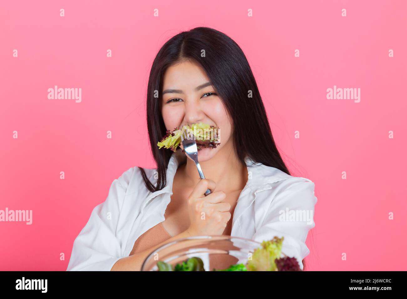 asiatische Frau, die gesundes frisches Gemüse mit Kopierraum, Beauty-Diät und vegetarisches Lifestyle-Konzept isst. Stockfoto