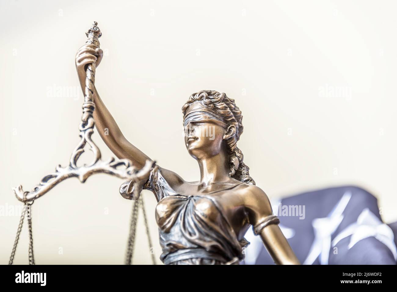 Die Statue der Gerechtigkeit Themis oder Iustitia, die Göttin der Gerechtigkeit mit verbundenen Augen gegen eine Flagge der Vereinigten Staaten von Amerika, als Rechtsbegriff. Stockfoto
