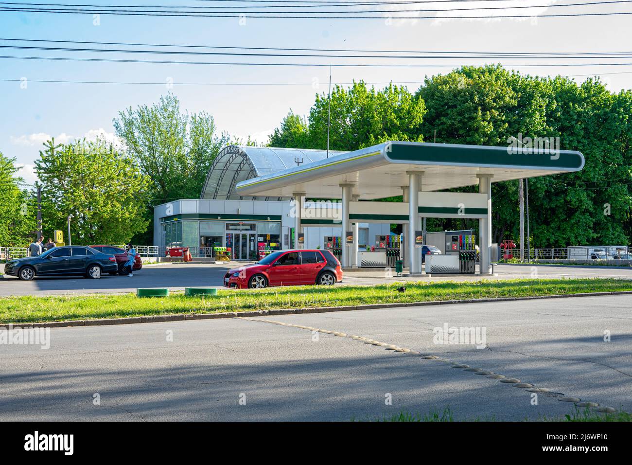 Vinnyzja, Ukraine - Mai 2020. Autotanken in der Nähe der Straße mit Autos und Menschen Stockfoto