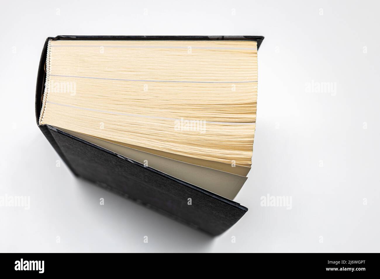 Ein dickes Volumen eines Papierbuches liegt auf einem weißen Tisch Stockfoto