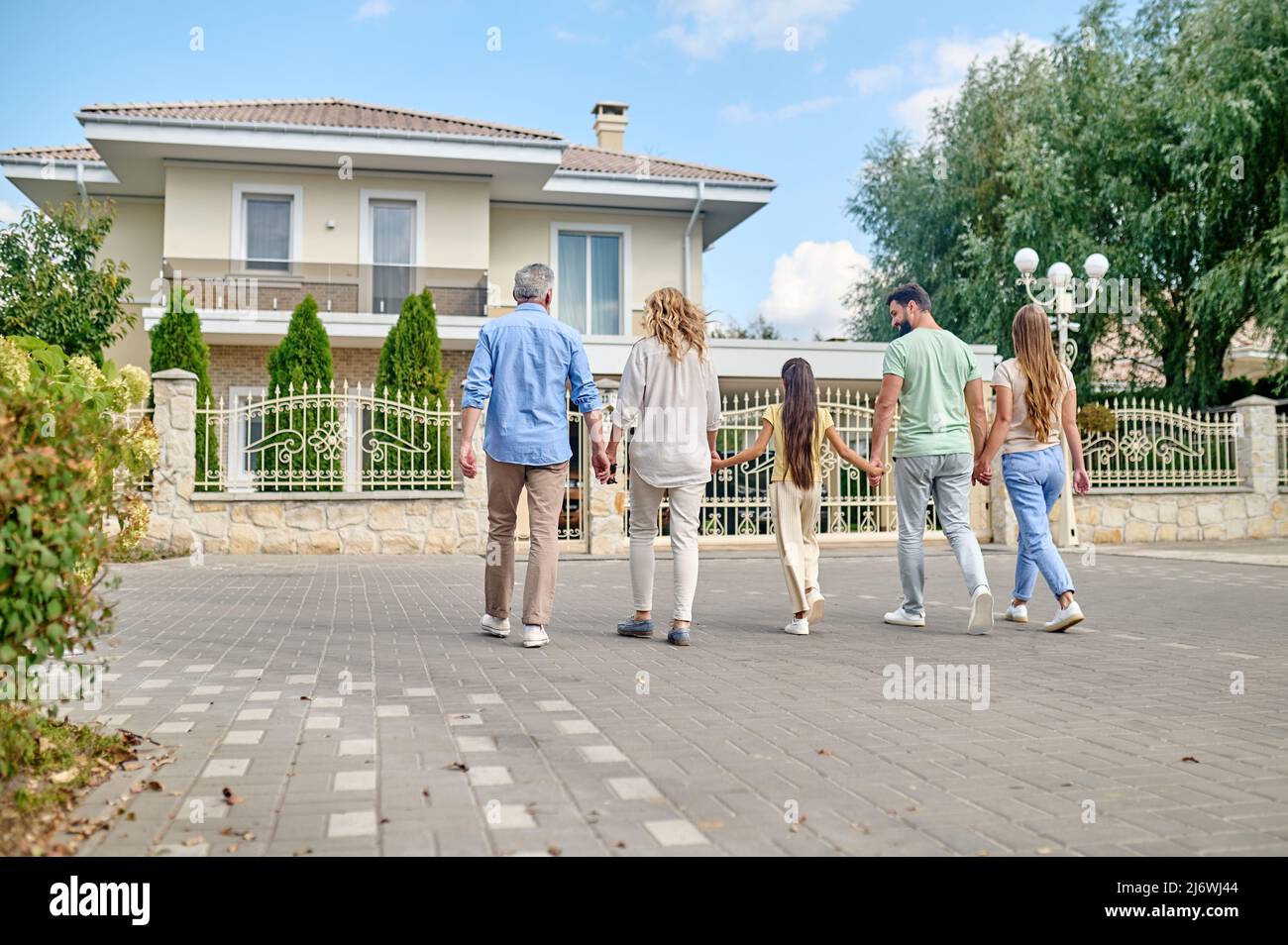 Eine große Familie, die Hand in Hand geht und glücklich aussieht Stockfoto