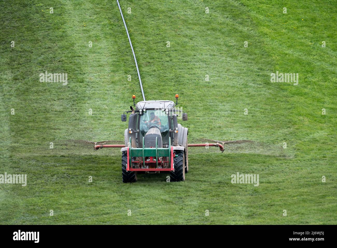 Verteilen von Gülle mit einem Valtra Traktor und einem Nabelsystem auf einer Wiese. Cumbria, Großbritannien. Stockfoto