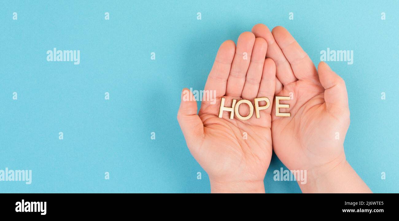 Das Wort Hoffnung in den Händen halten, Vertrauen und glauben Konzept, Vertrauen in die Zukunft haben, hoffnungsvoll positive Denkweise Stockfoto