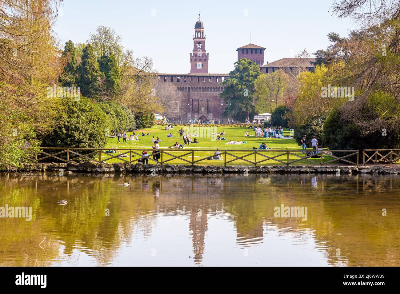 Die Türme des Castello Sforzesco spiegeln sich an einem sonnigen Frühlingstag im Teich des Simplonparks (Parco Sempione) in Mailand, Italien, wider. Stockfoto