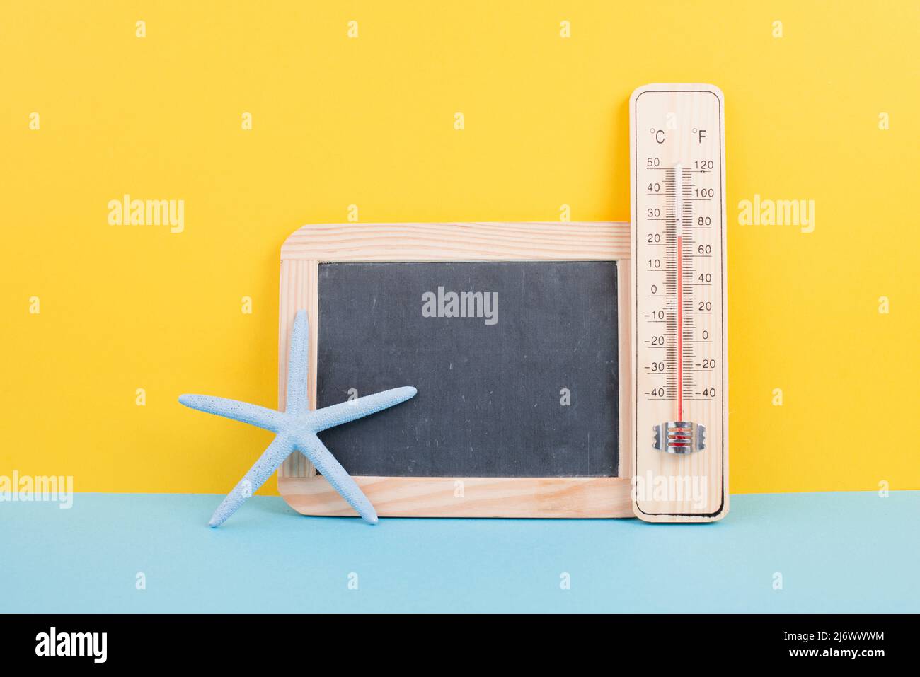 Leere Tafel mit Thermometer und Sternfisch, Hintergrund im Urlaub, Sommerurlaub, heißes Wetter, Umweltproblem Stockfoto