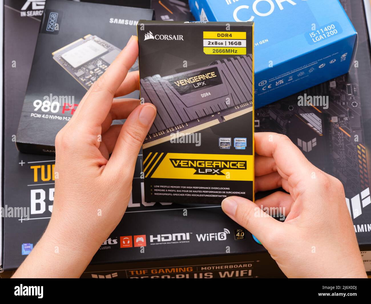 Tambow, Russische Föderation - 07. April 2022 Eine Frau hält eine Box mit einem Corsair DDR4-Speicher über andere Boxen mit brandneuen Komponenten Stockfoto