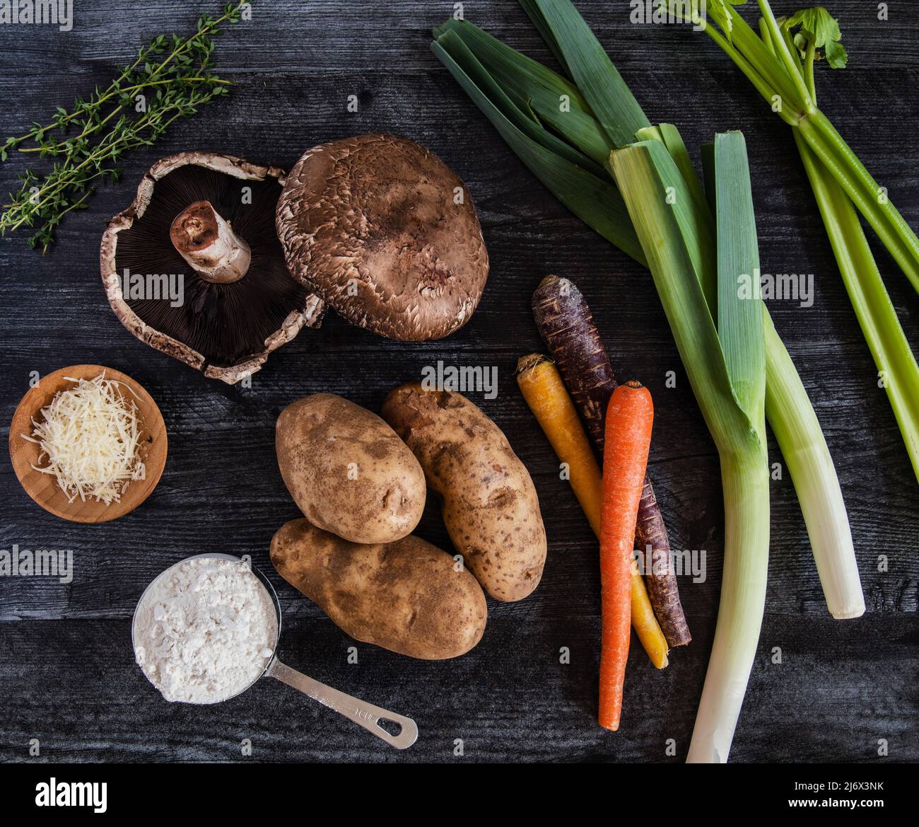 Frische Zutaten aus Pilzen, Karotten, Kartoffeln, Sellerie, Lauch und Thymian Stockfoto