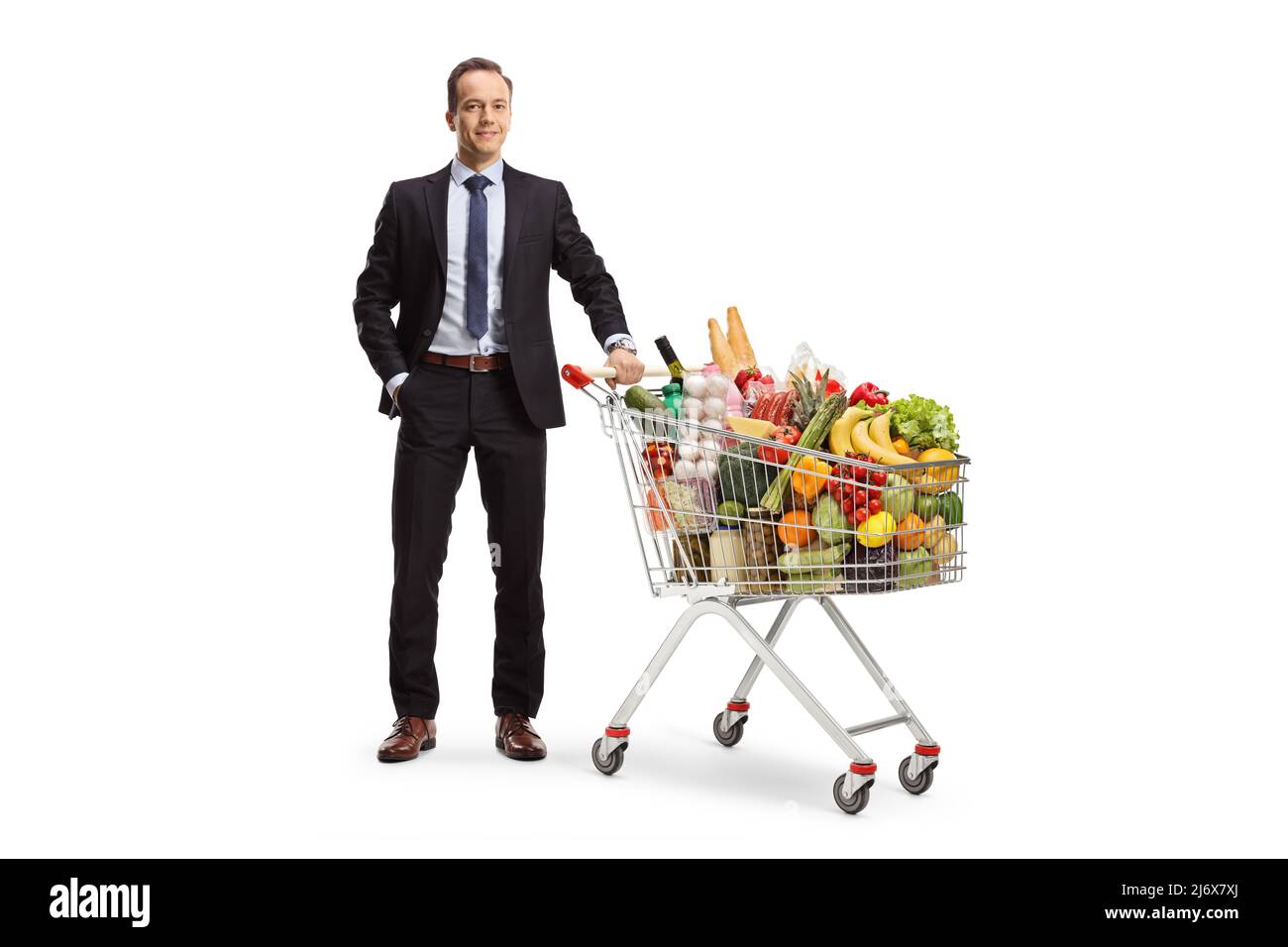 In voller Länge Porträt eines Geschäftsmannes posiert mit Essen in einem Einkaufswagen isoliert auf weißem Hintergrund Stockfoto