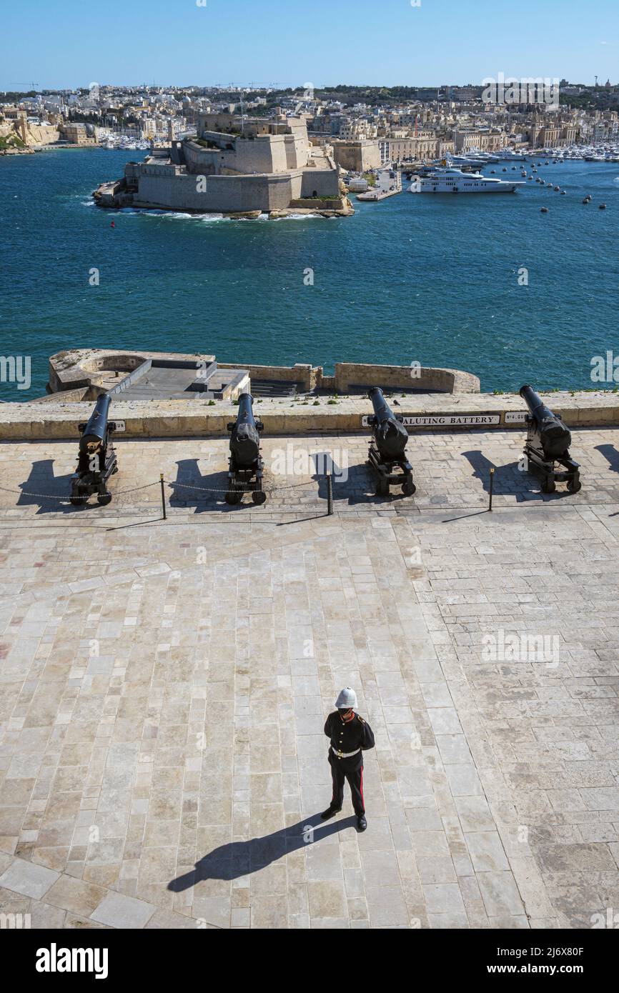 Ein Einzelkämpfer bei der Saluting Battery mit Blick über den Grand Harbour nach Fort St Angelo, Valletta, Malta Stockfoto