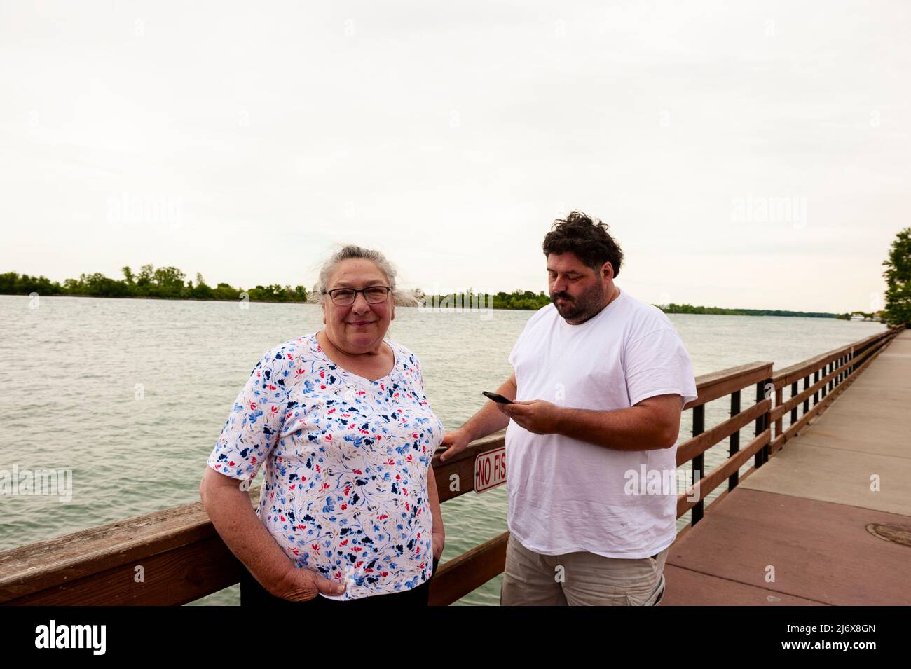 Mutter und Sohn entspannen sich am Ufer des Detroit River in Wyandotte, 11 Meilen stromabwärts von Detroit, Michigan, USA. Stockfoto