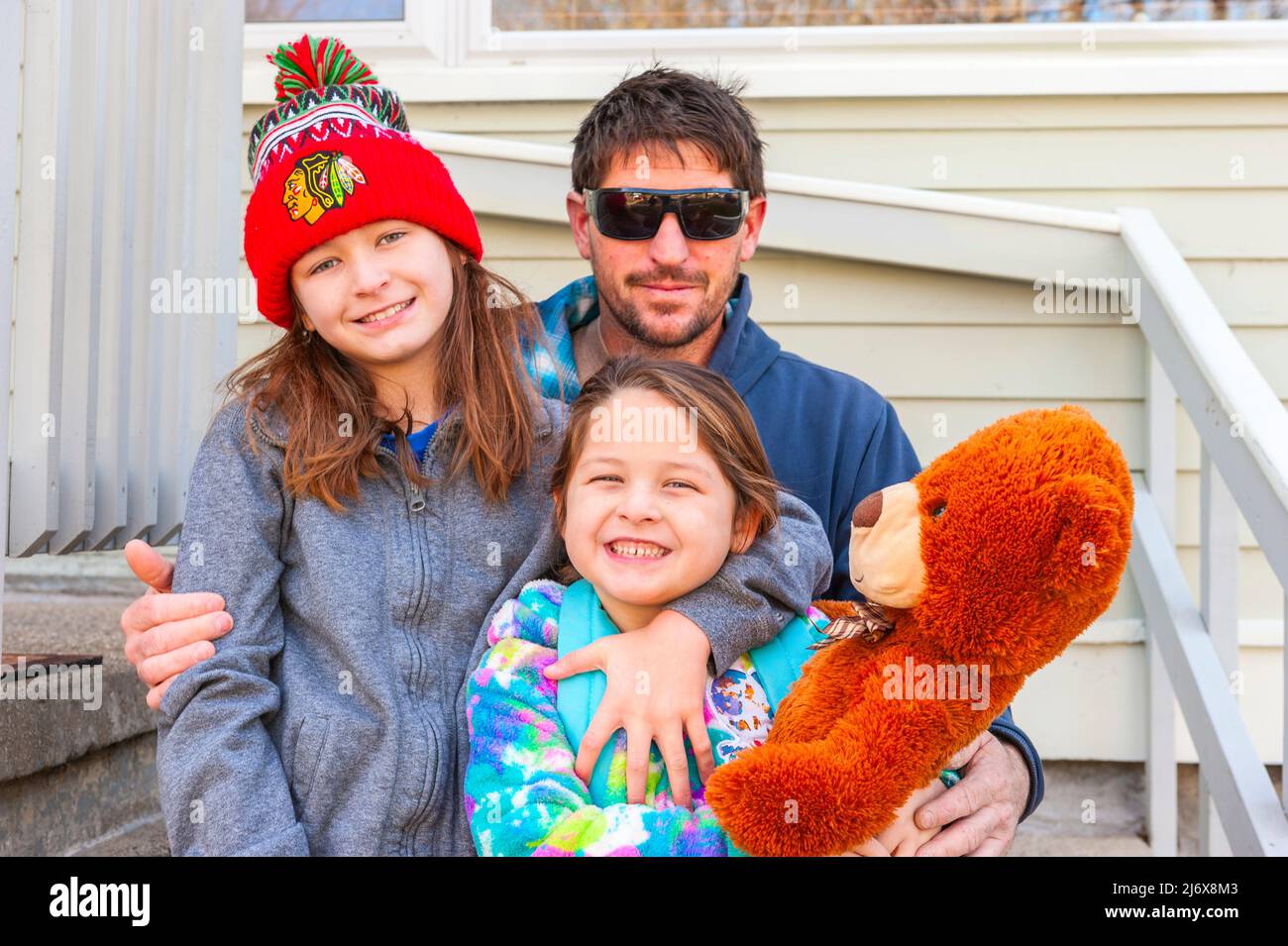 Glückliche alleinerziehende Arbeiterfamilie, die für die Kamera in Ludington, Michigan, USA posiert. Stockfoto