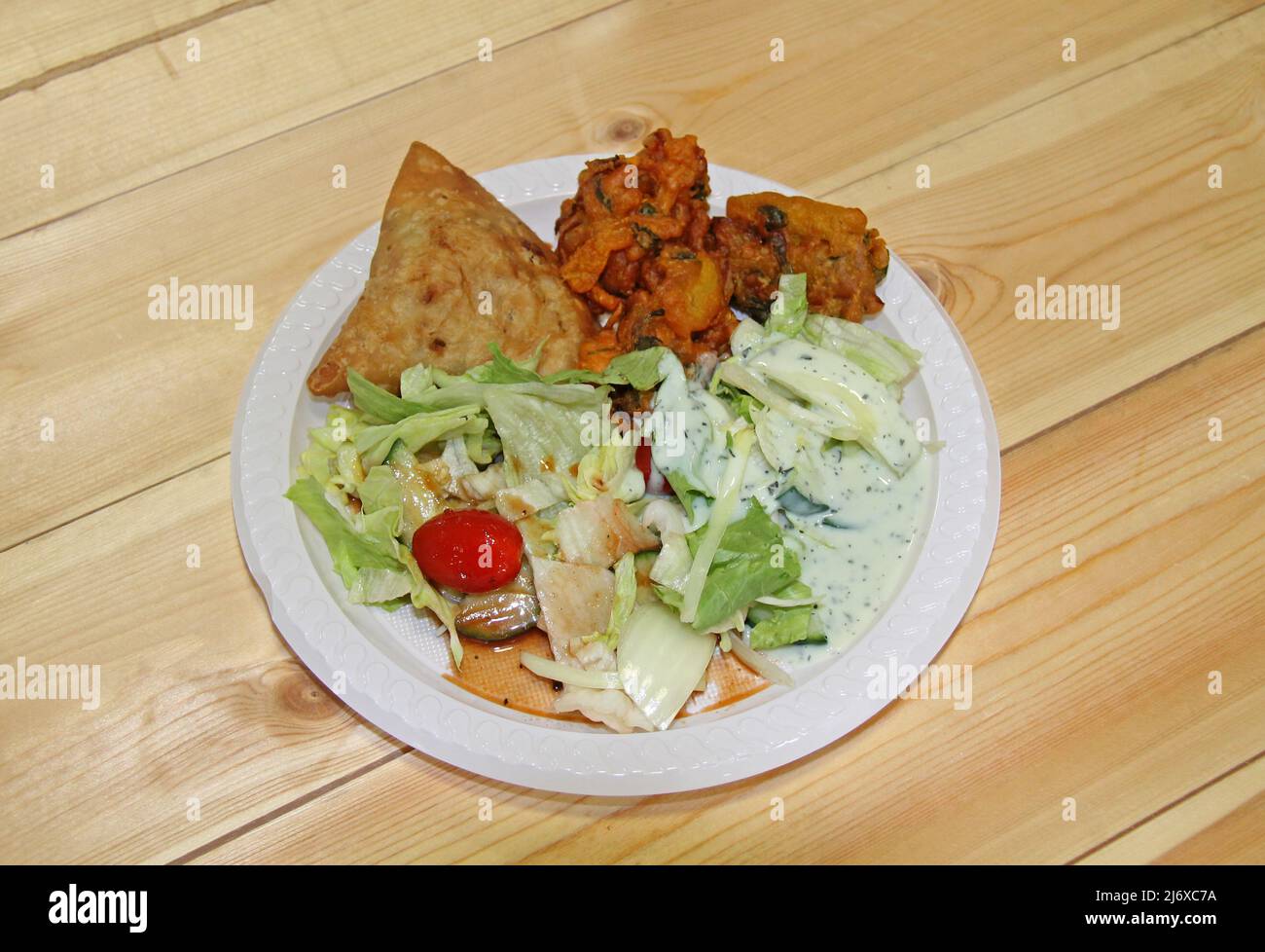 Eine vegane Salatmahlzeit mit Samosas und Zwiebelbhajis. Stockfoto