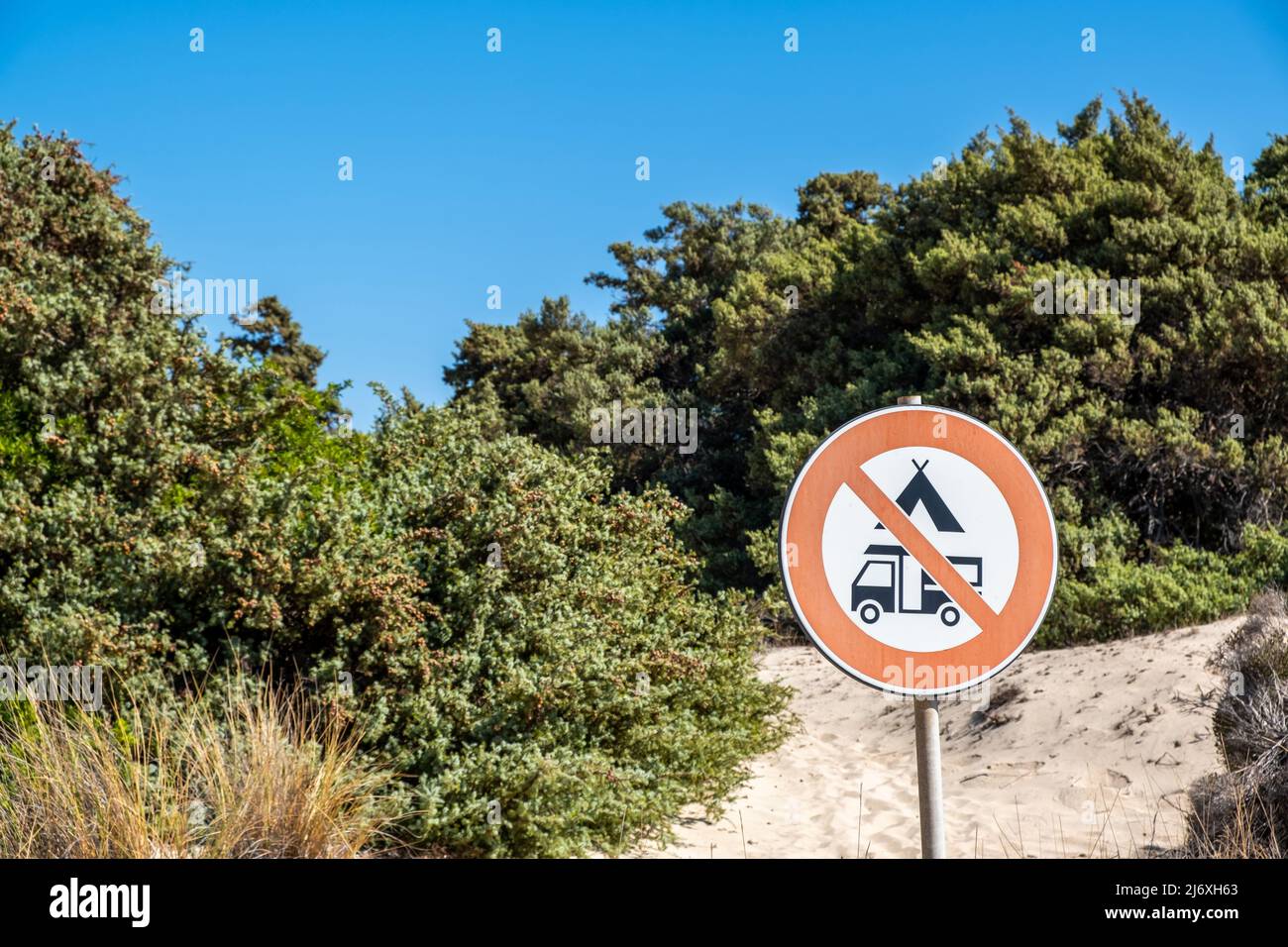 Kein Camping, kein Camper-Schild, verwischen Sie den Hintergrund der Natur. Warnschild, Zelte und Wohnmobil verboten am Strand in der Nähe der Pflanzen, Elafonisos Insel Gree Stockfoto