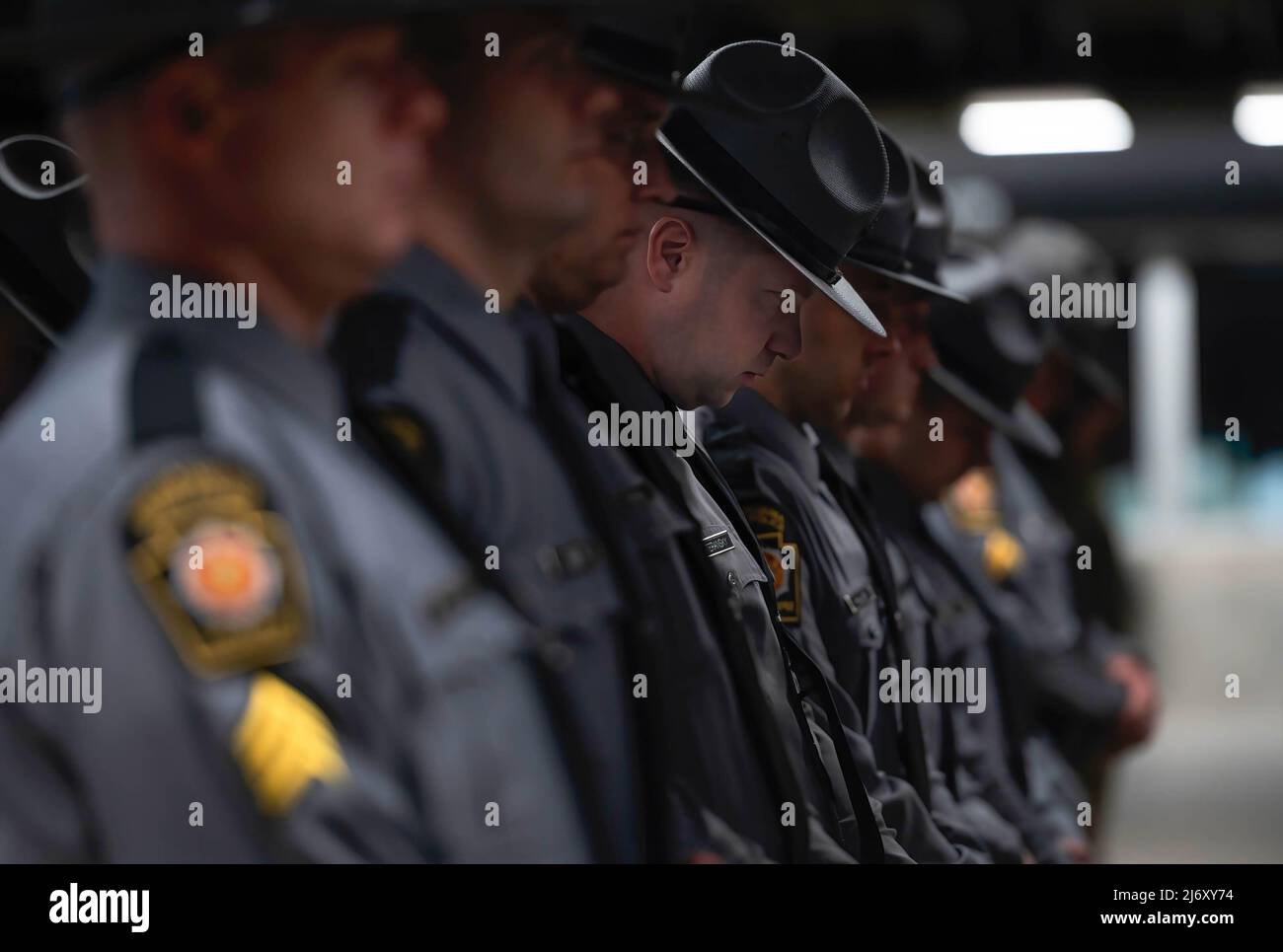 Ein Polizeikommissar der Pennsylvania State Police beugt sich während eines Gebets beim PA State Police Memorial Programm mit dem Kopf. Die Polizeitruppe P der Pennsylvania State Police in Wilkes-Barre hielt einen Gedenkgottesdienst für die Staatspolizei ab, der in den letzten 117 Jahren seines Bestehens gestorben ist. Seit der letzten persönlichen Zeremonie wurden 5 Staatspolizisten in die Liste aufgenommen. Zwei Soldaten starben nach einem Vorfall mit einem betrunkenen Fahrer in Philadelphia im März. Stockfoto