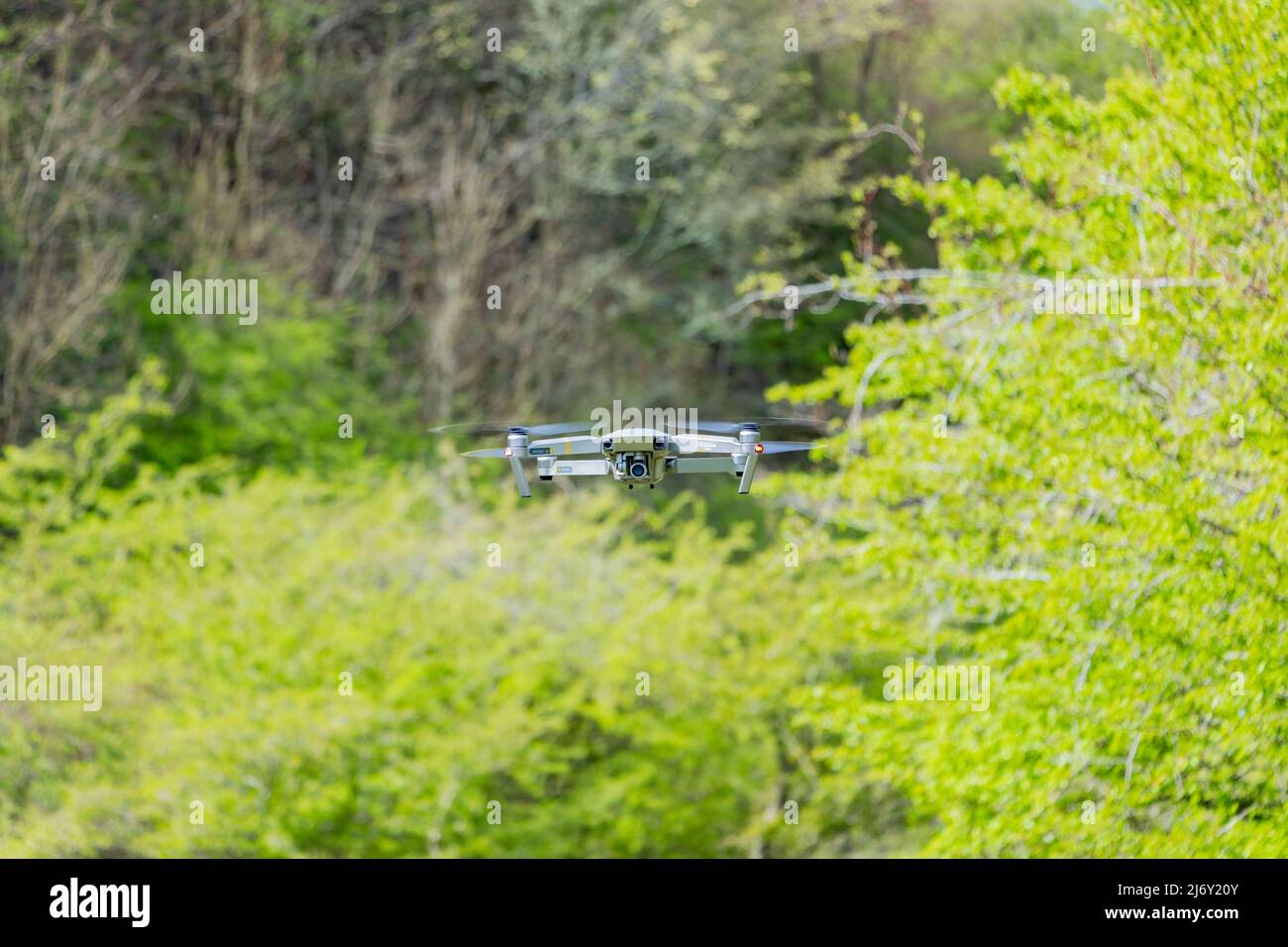 DJI Mavic Pro Drohne schwebt vor grünem Gras Büsche Hintergrund Stockfoto