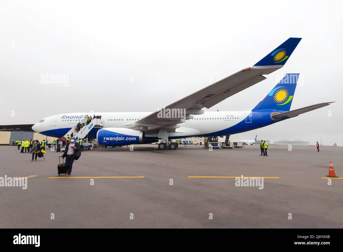 Ruandair Airbus A330-Flugzeug am Flughafen Kigali mit Passagieren, die in Ruanda landen. Flugzeug von Ruandair A330-200. Passagiere, die aus dem Flugzeug laufen. Stockfoto