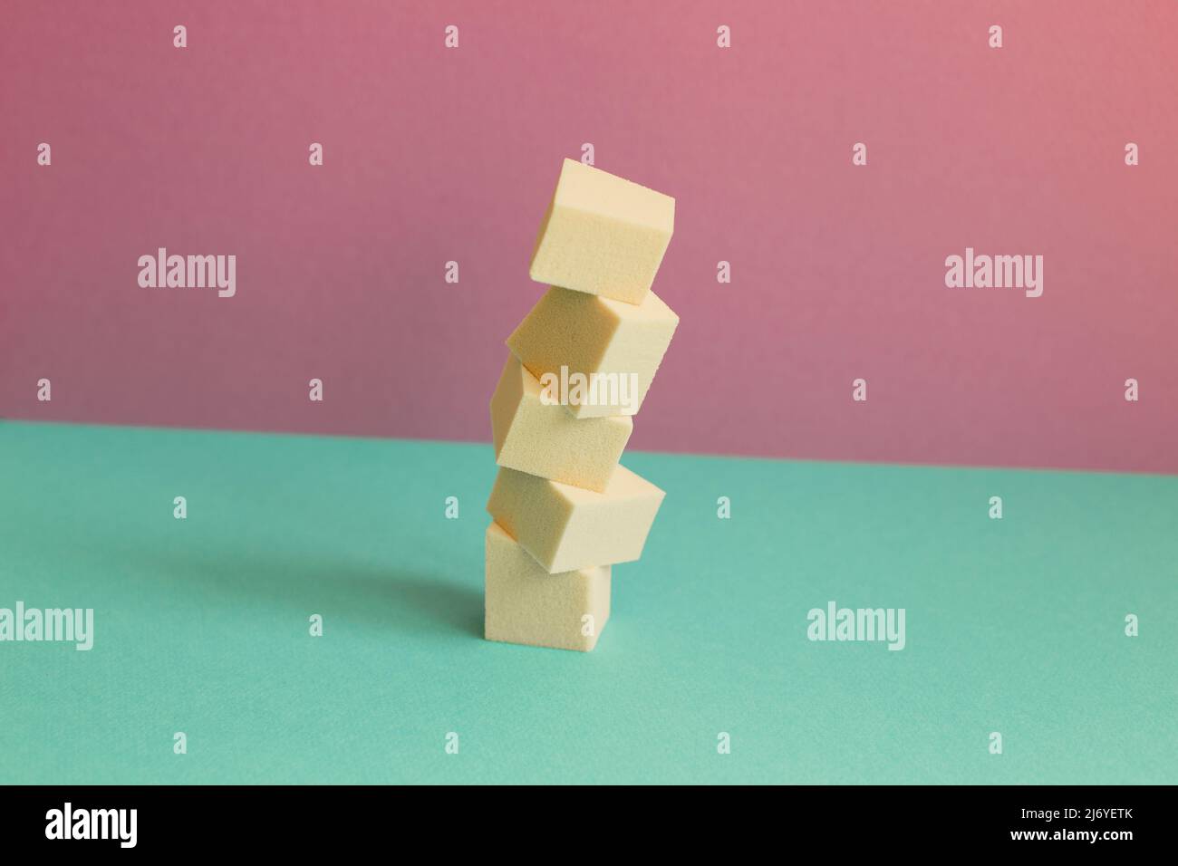 Stapel von Make-up Schwamm auf minzgrünen Tisch. Rosa Wand Hintergrund Stockfoto