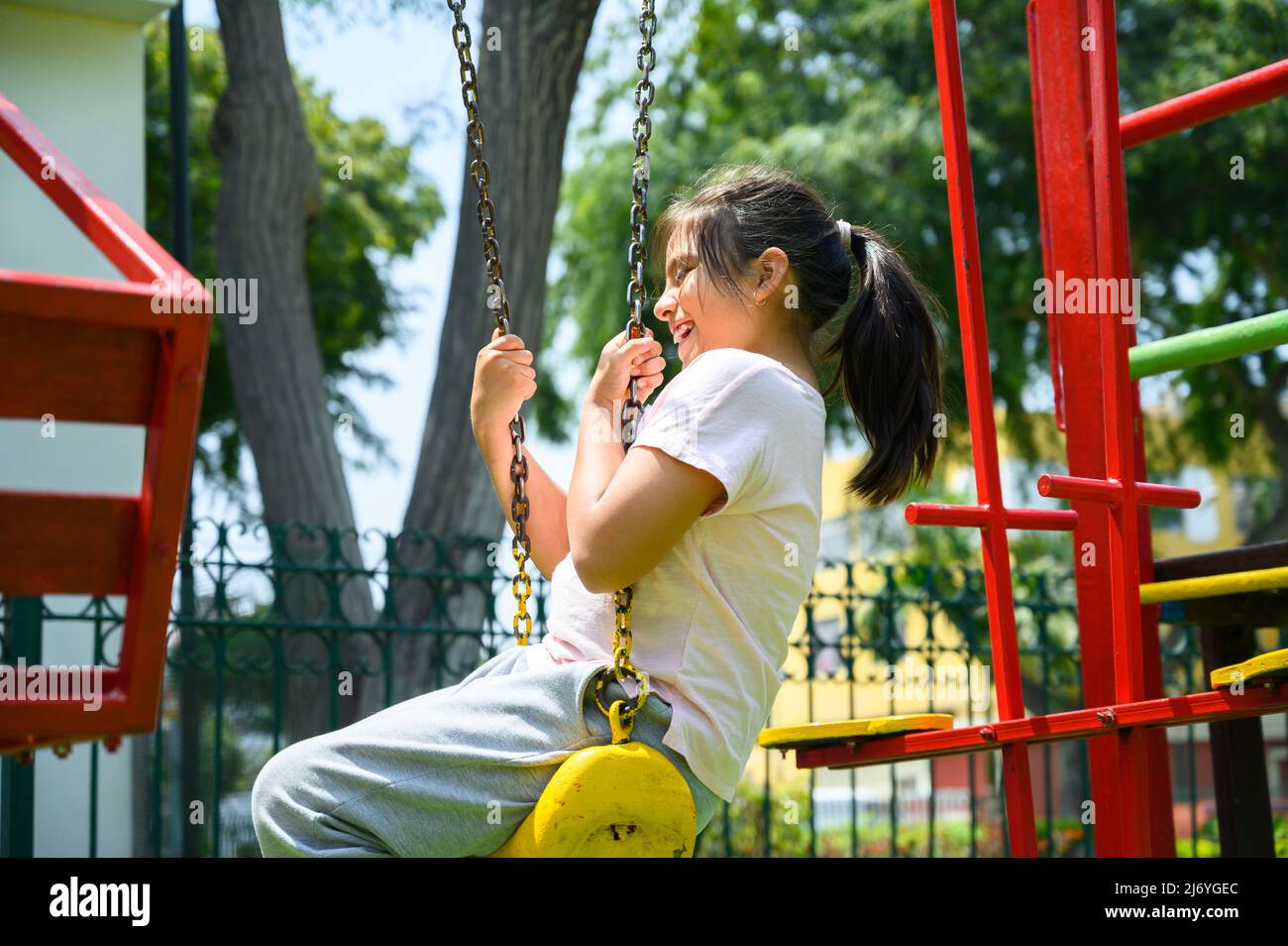 Happy Little hispanic Mädchen Kind Spaß zu spielen im Park im Sommer mit Lächeln und lachen gesund, liebenswert Mädchen Spaß auf einer Schaukel im Sommer. Happy Urlaub Lifestyle-Konzept Stockfoto