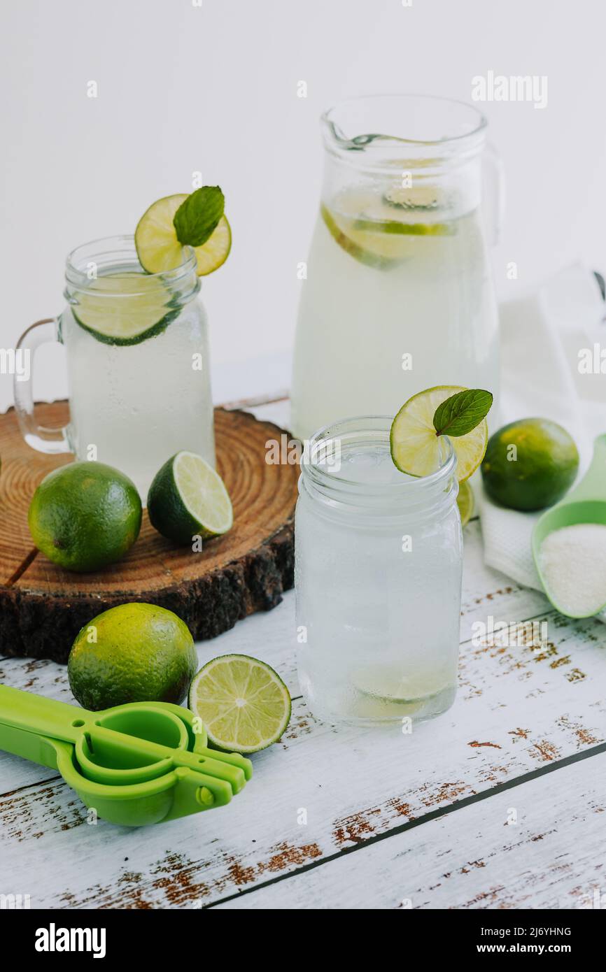 Glas Limonadengetränk mit grünen Zitronen oder Limette auf weißem Hintergrund in Lateinamerika Stockfoto