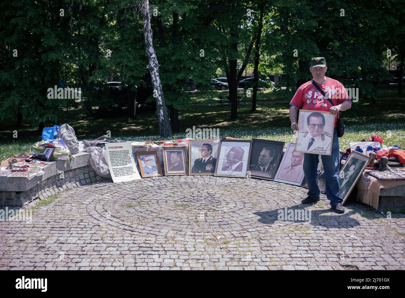 Belgrad, Serbien, 4. Mai 2022: Ein Mann, der eine Sammlung von Porträts des Marschalls Tito vor dem Museum für jugoslawische Geschichte zeigt Stockfoto