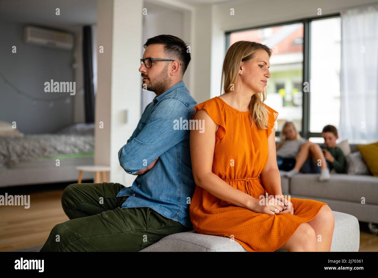 Traurige, nachdenkliche Paare, die an Beziehungsprobleme denken, die auf dem Sofa sitzen, Konflikte in der Ehe. Stockfoto