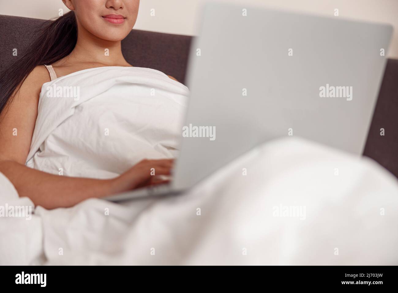 Asiatische junge Frau mit modernen Notebook zu Hause Stockfoto