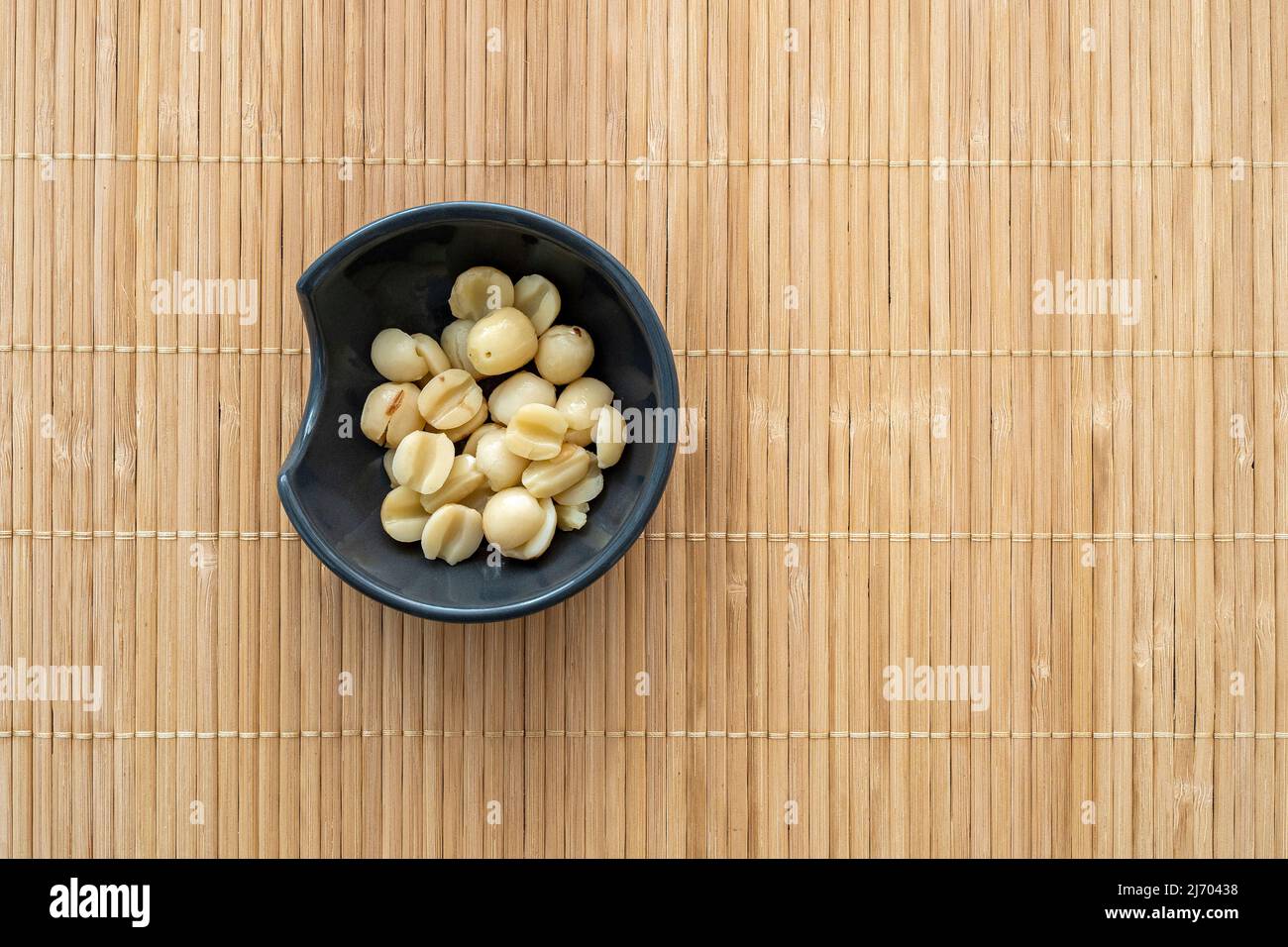 Süße Lotuskerne auf einer kleinen Schüssel. Lotus-Bohnen aus der Dose als traditionelles asiatisches Essen, Snack von oben Stockfoto