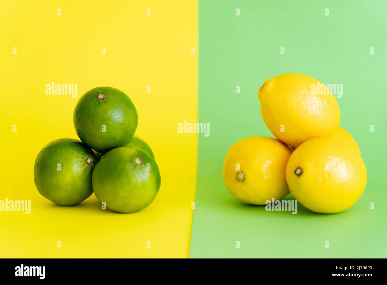 Limetten und Zitronen auf grünem und gelbem Hintergrund Stockfoto