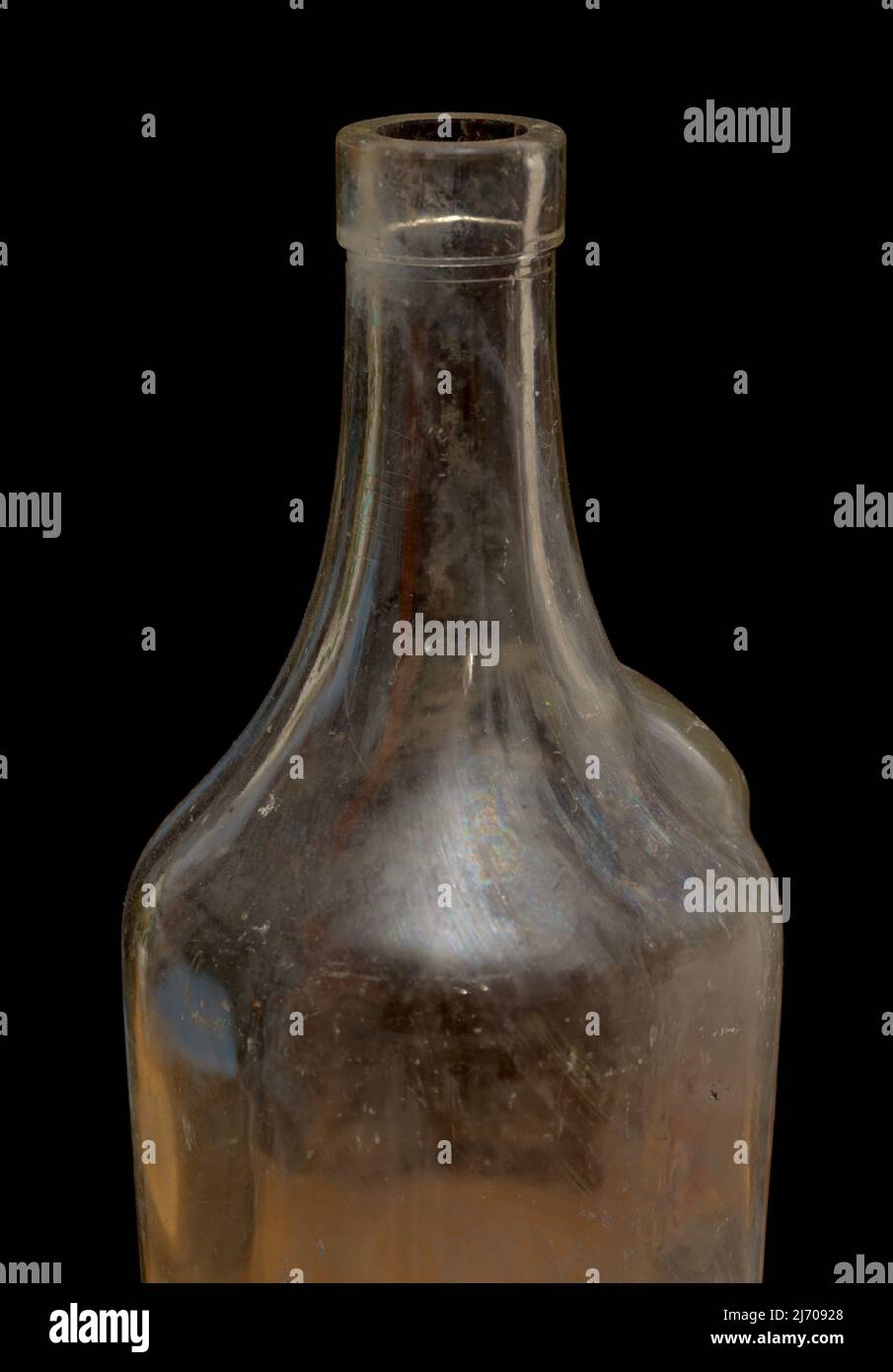 Alte Flasche aus klarem Glas, die an einem Ufer gefunden wurde, natürlicher Frosting und schillernder Effekt auf der Oberfläche, isoliert auf schwarzem Hintergrund Stockfoto