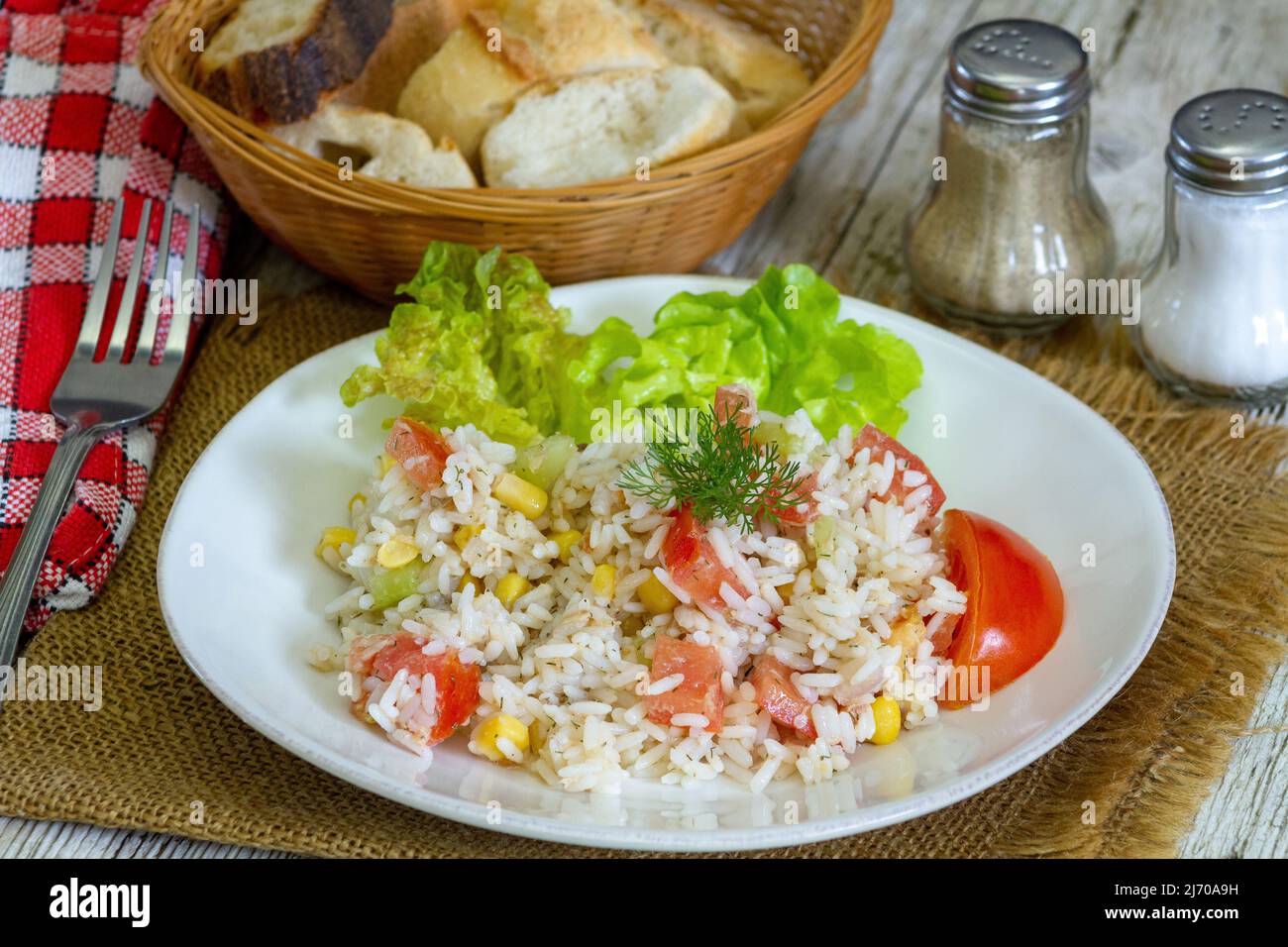 Salat Reis auf einem Teller mit Tomaten und Mais Stockfoto